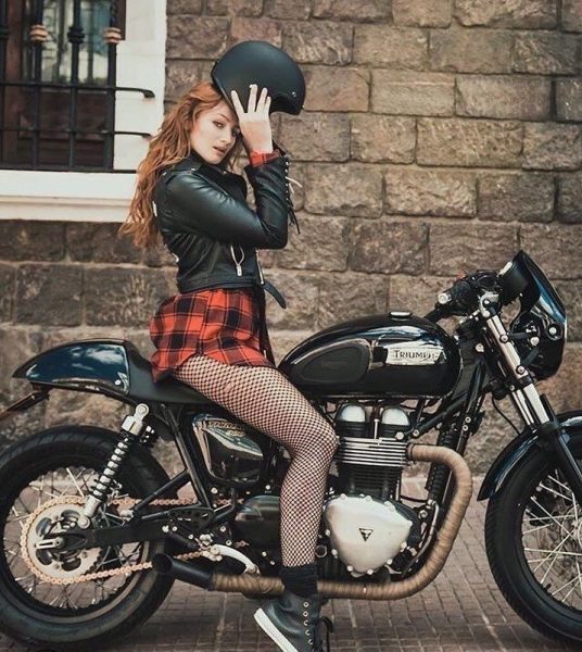 スクランブラーバイクに乗る女性の服装は何ですか？